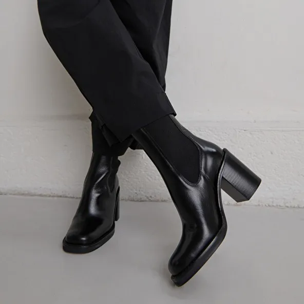 Ankle boots with overflowing heels in black leather